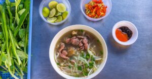 (bowl of beef pho with toppings)