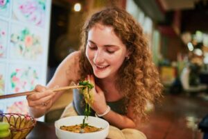 (woman eating pho)